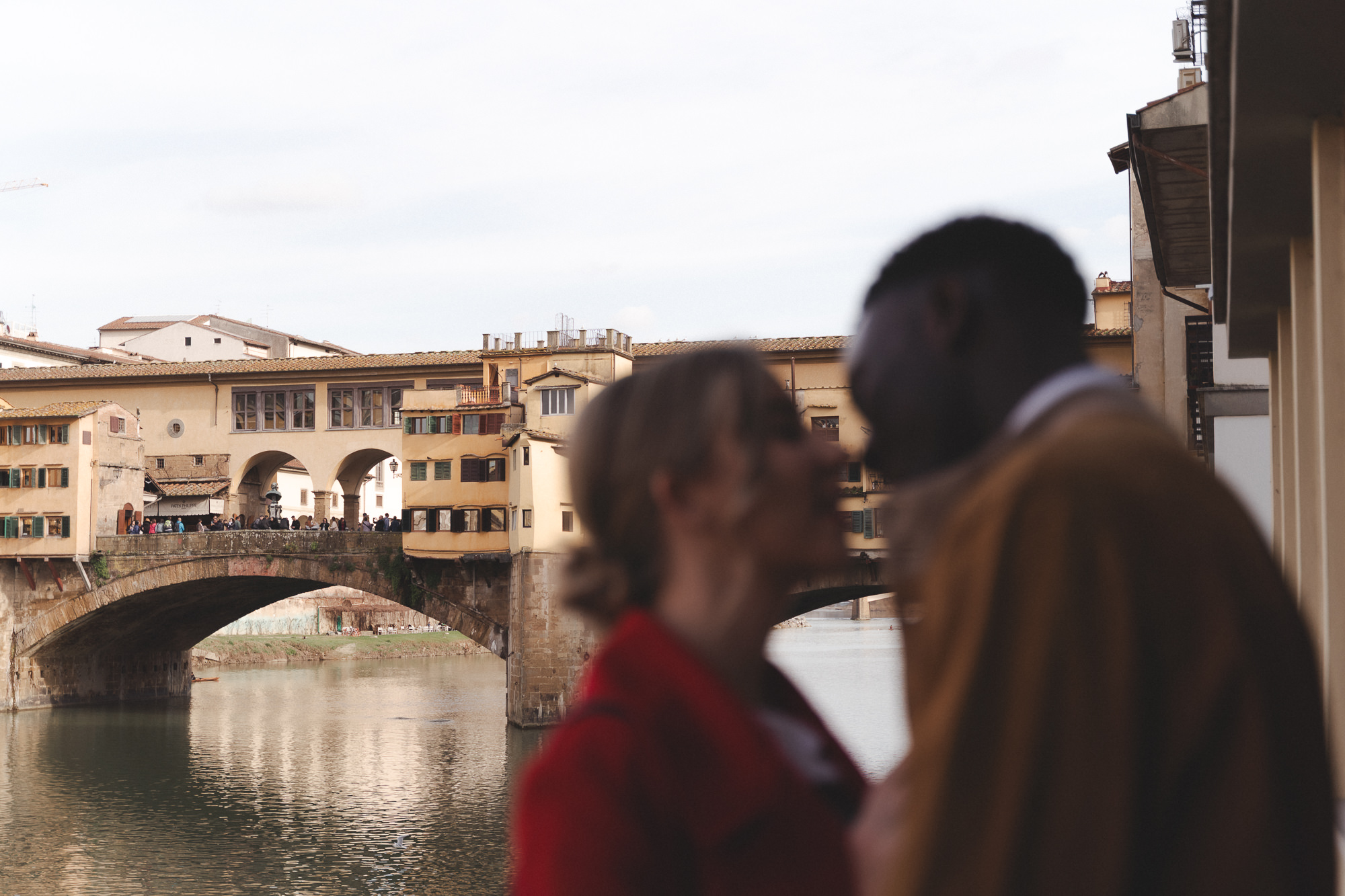Scenic view of Ponte Vecchio bridge in Florence with a blurred couple in the foreground.