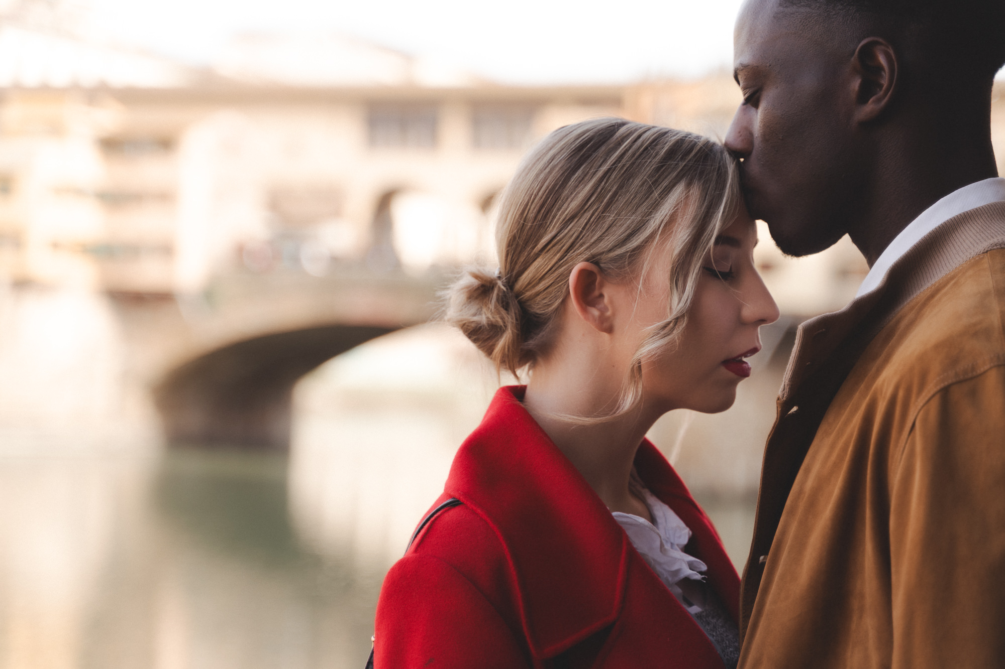 Close-up portrait of a woman with red lipstick and a red coat during a Florence fall session.