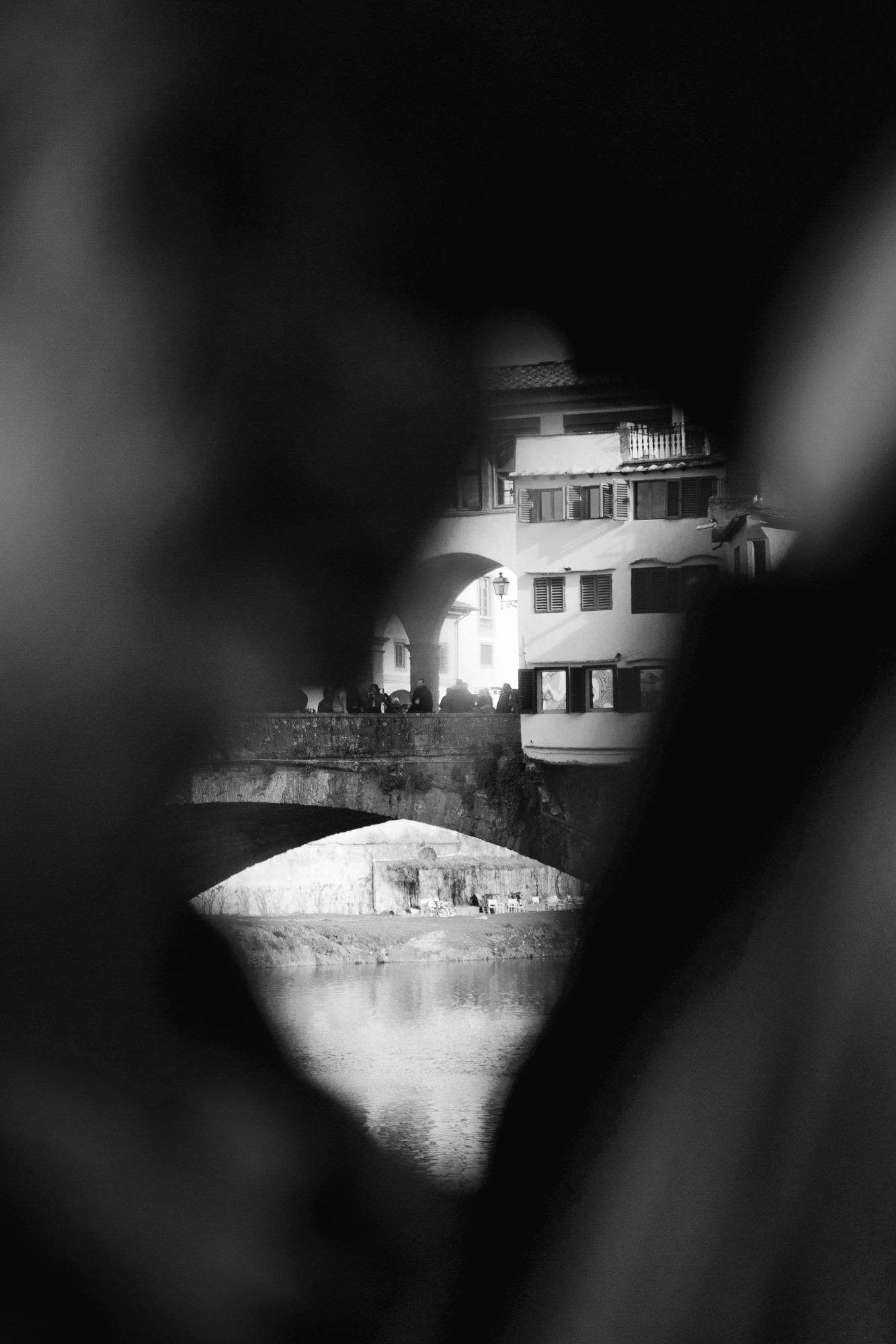 Happy couple walking hand-in-hand near the Arno river in Florence wearing autumn attire.