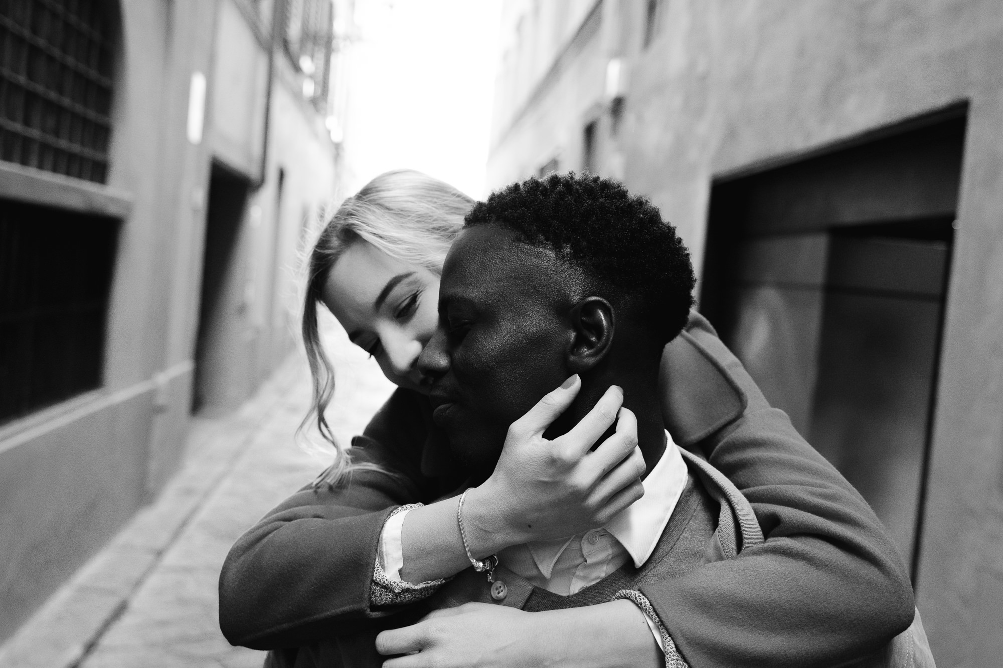 B&W close-up of the couple hugging in a narrow historic alley