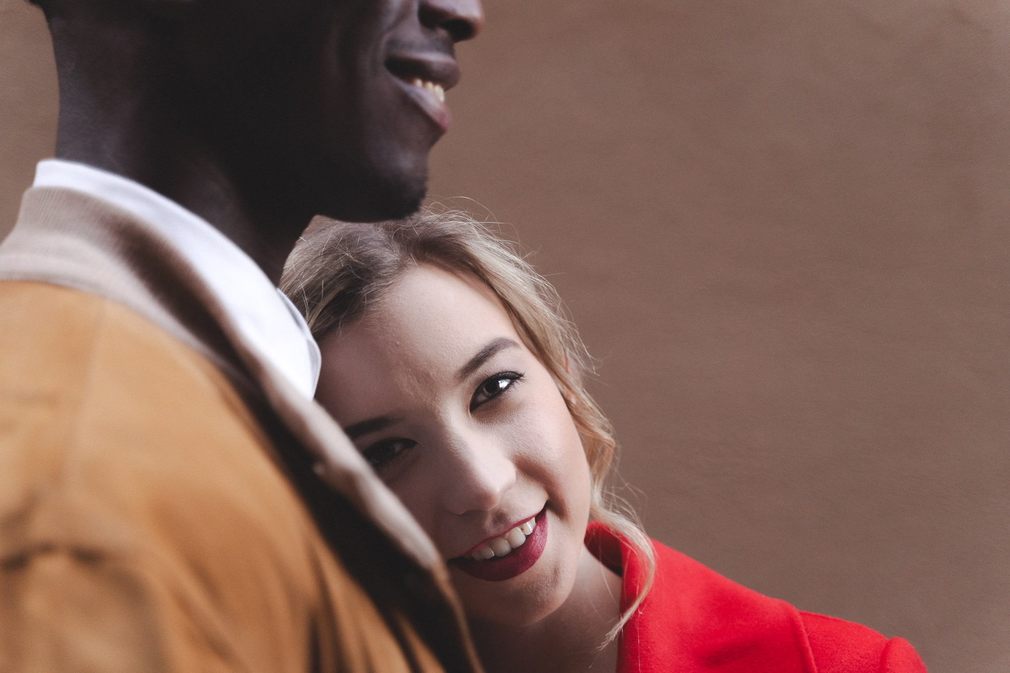 Close-up of the woman resting her head on the groom's shoulder in the street