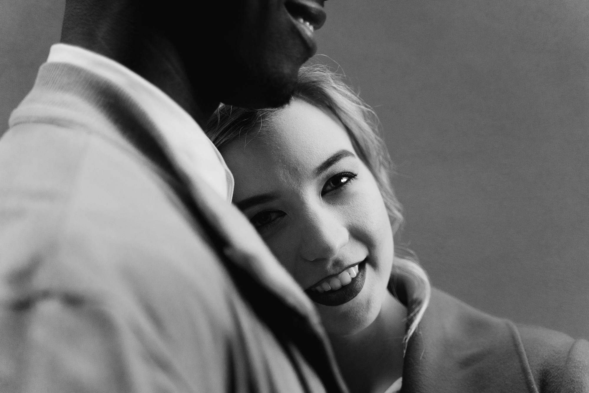 B&W version of the woman resting her head on the groom's shoulder