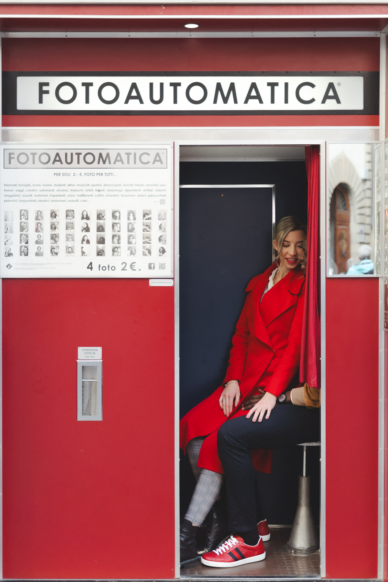 Wide shot of the couple sitting together inside the vintage red booth